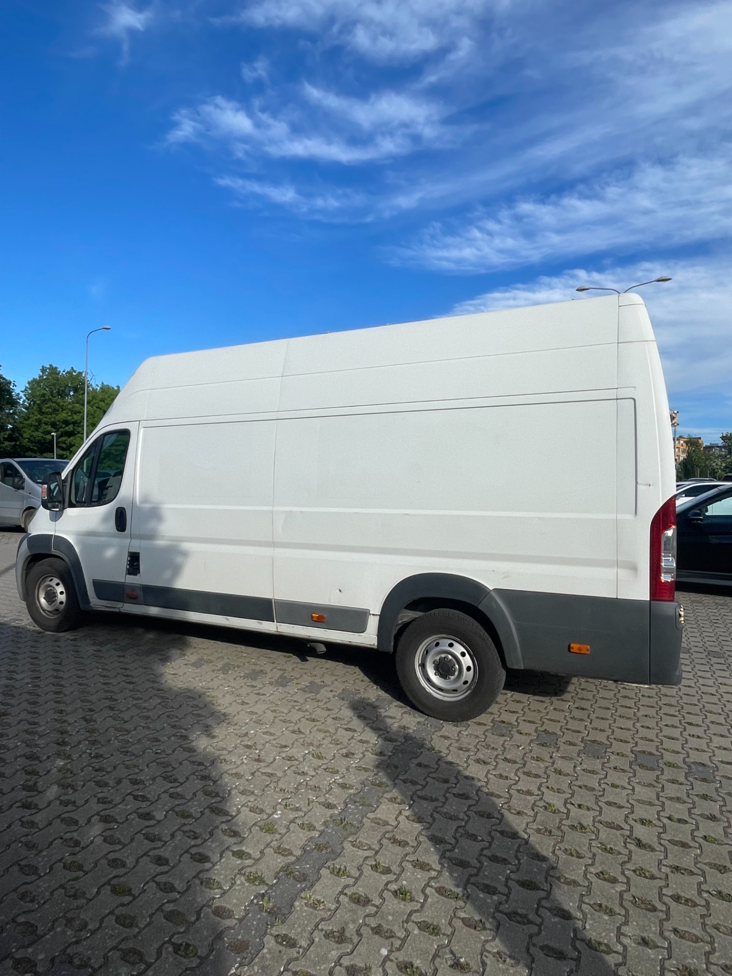 Biały dostawczy Citroën Jumper L3H3 firmy Mrówka Trans zaparkowany na placu w Szczecinie.